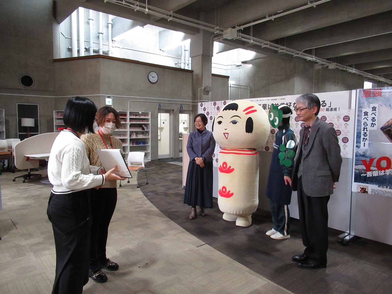 仙台弁こけしと動画撮影を行う大隅典子附属図書館長・有光秀行副館長